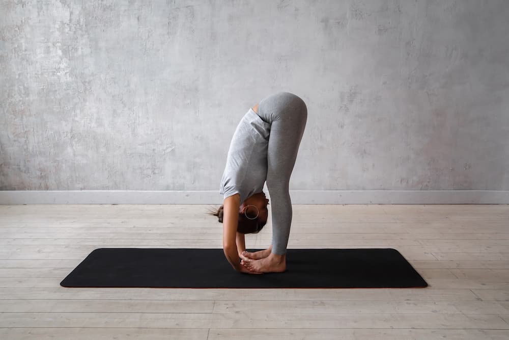 This is a photo of a lady doing the standing forward bend pose