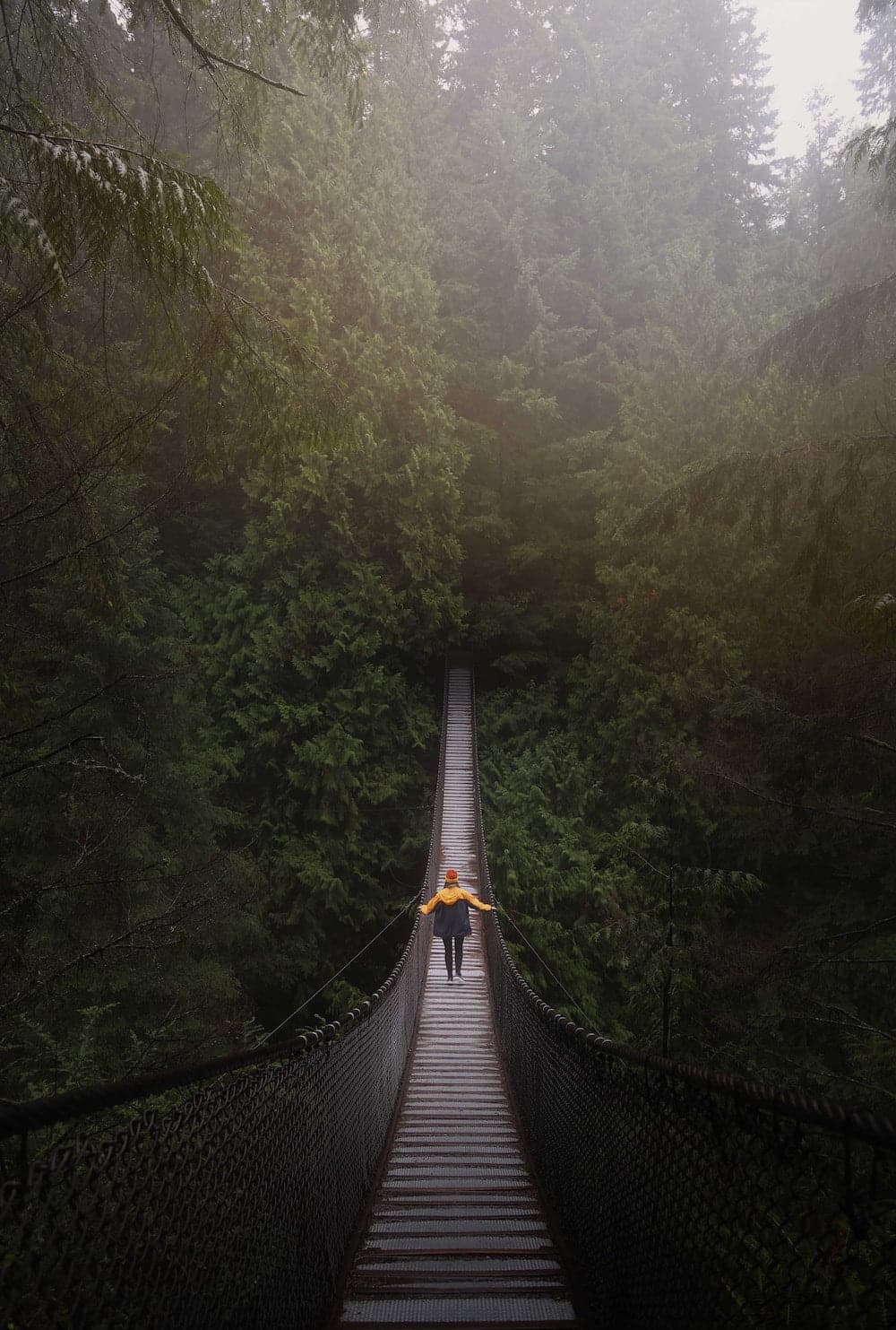 woman crossing a rope bridge