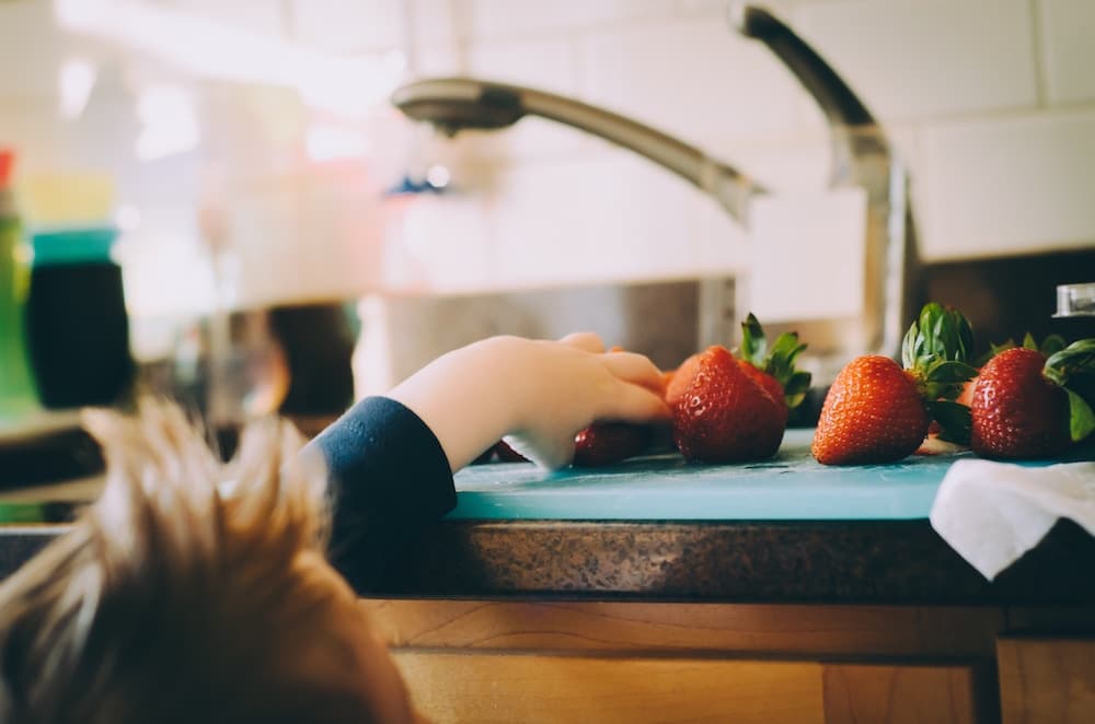 child eating strawberries