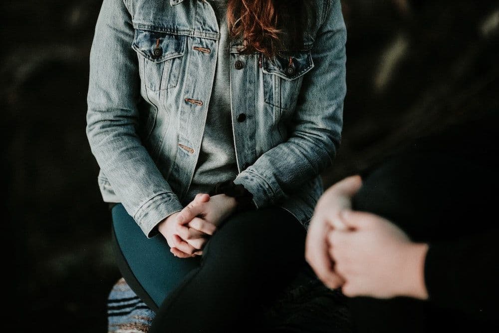 Close-Up-Image-of-Woman-with-Hands-Clasped-in-Lap-1