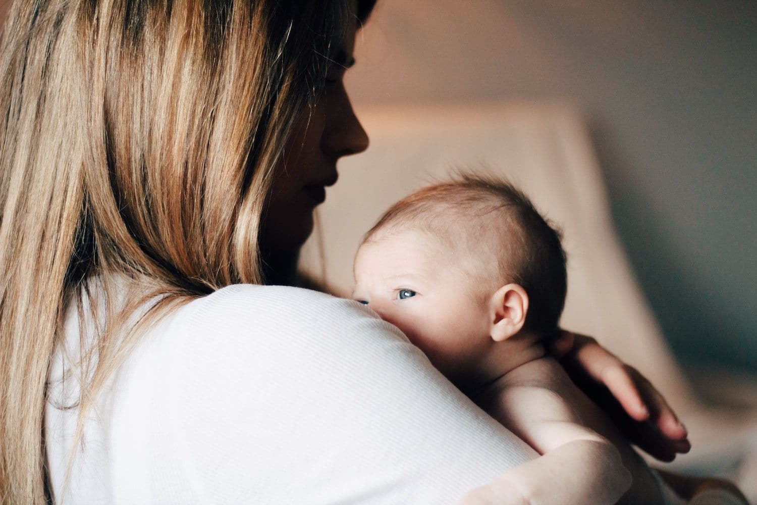 Image shows a parent holding their baby.