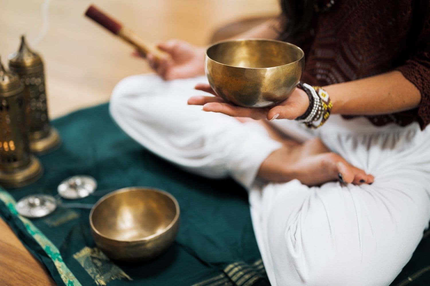 Person sat crossed-legged holding a sound bowl.