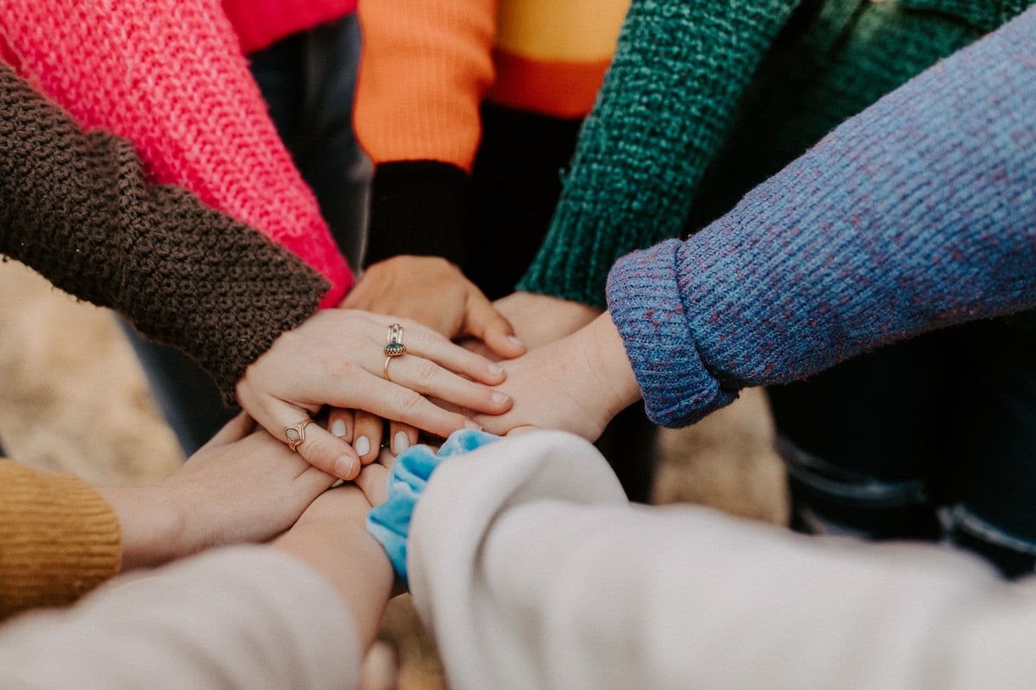 Image shows people putting their hands together.