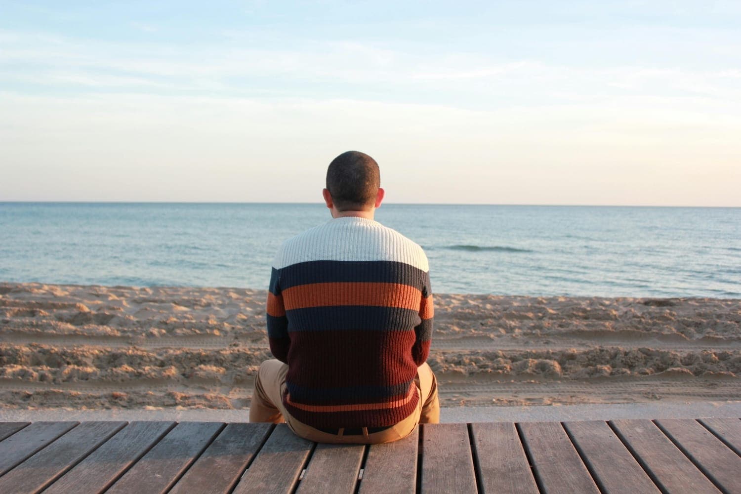 Person sitting by the sea