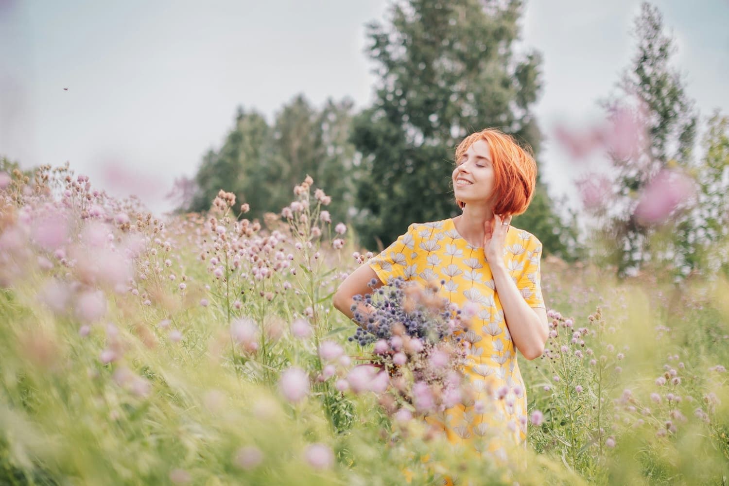 Woman stood smiling in flower field.