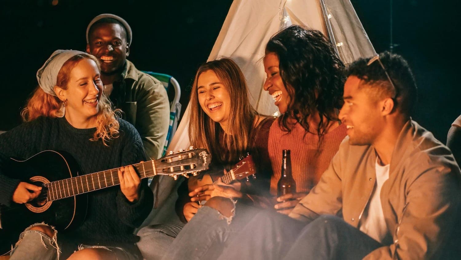 Frinds camping and playing guitar